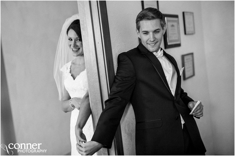 bride and groom holding hands around door
