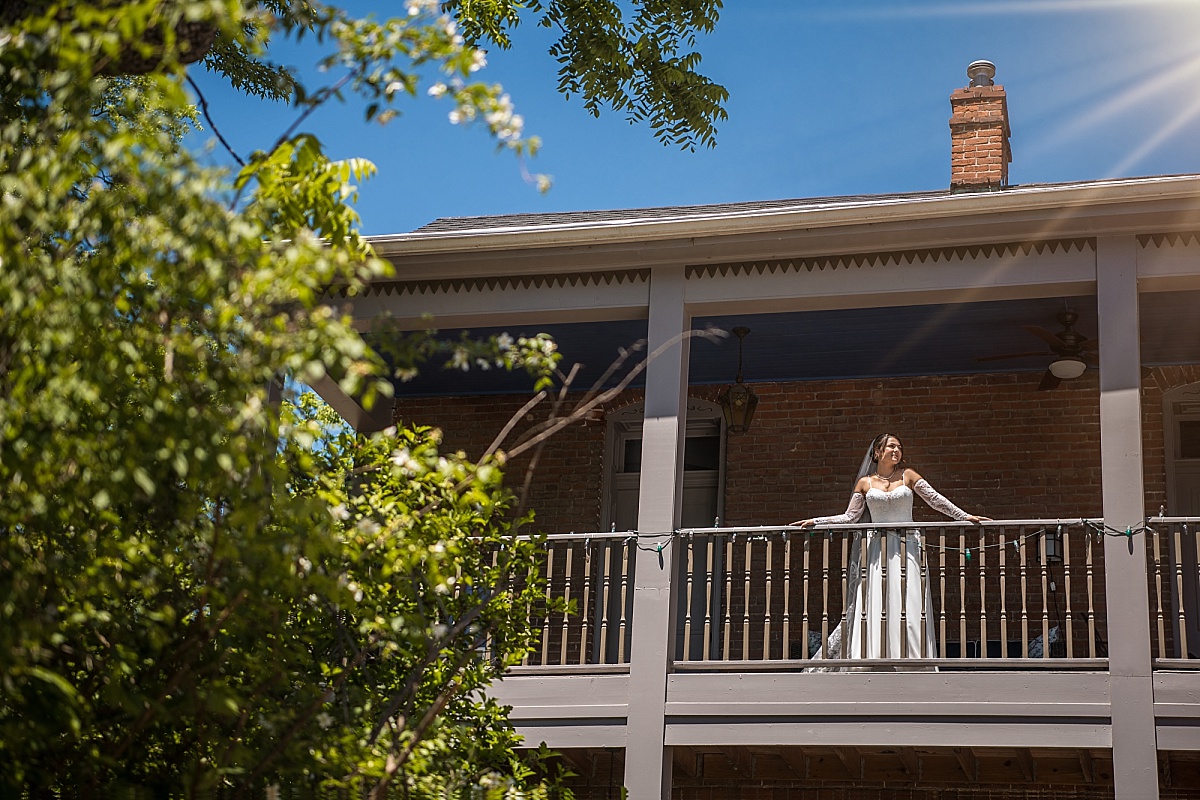 Grace stands on the balcony at Main Street Inn before her Ste. Genevieve wedding