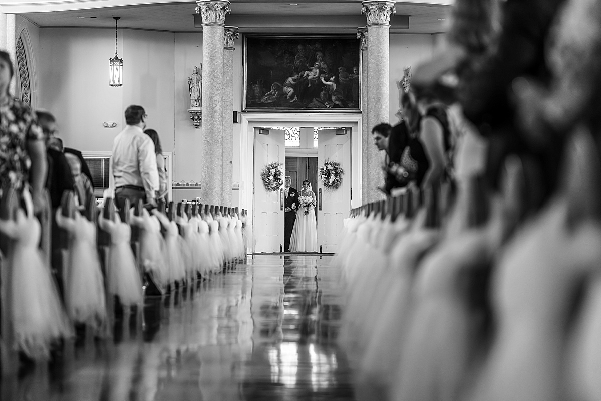 Black and white photo of Grace and her father entering Ste. Genevieve Catholic Church