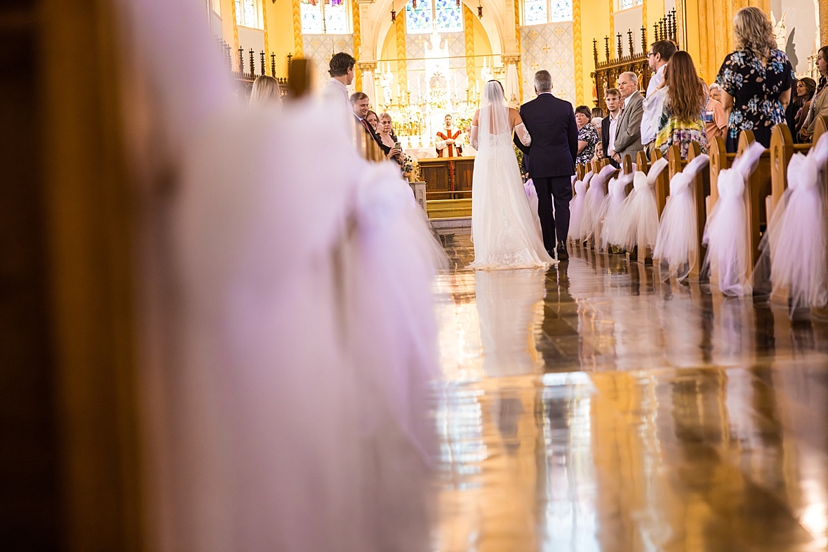 Grace walks down the aisle with her father at Ste. Genevieve Catholic Church