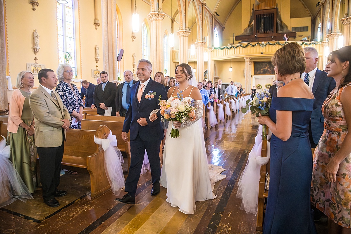Grace walks down the aisle with her father at Ste. Genevieve Catholic Church