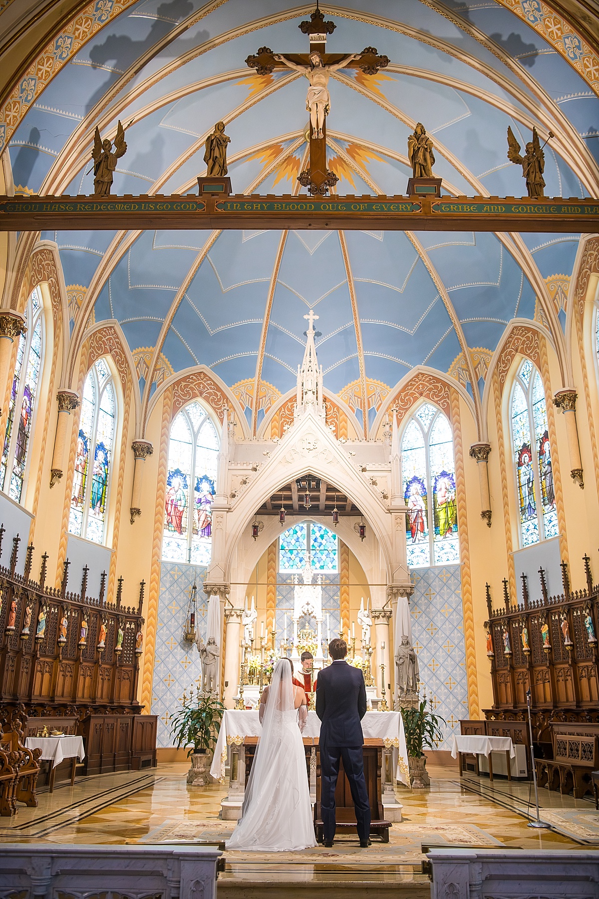 Grace and Alex kneel at the altar during their Catholic wedding ceremony