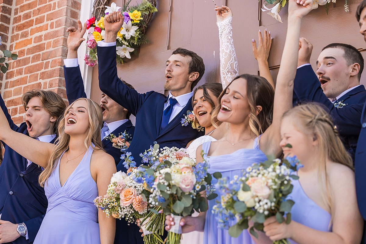 Grace, Alex, and their wedding party cheer outside the church doors