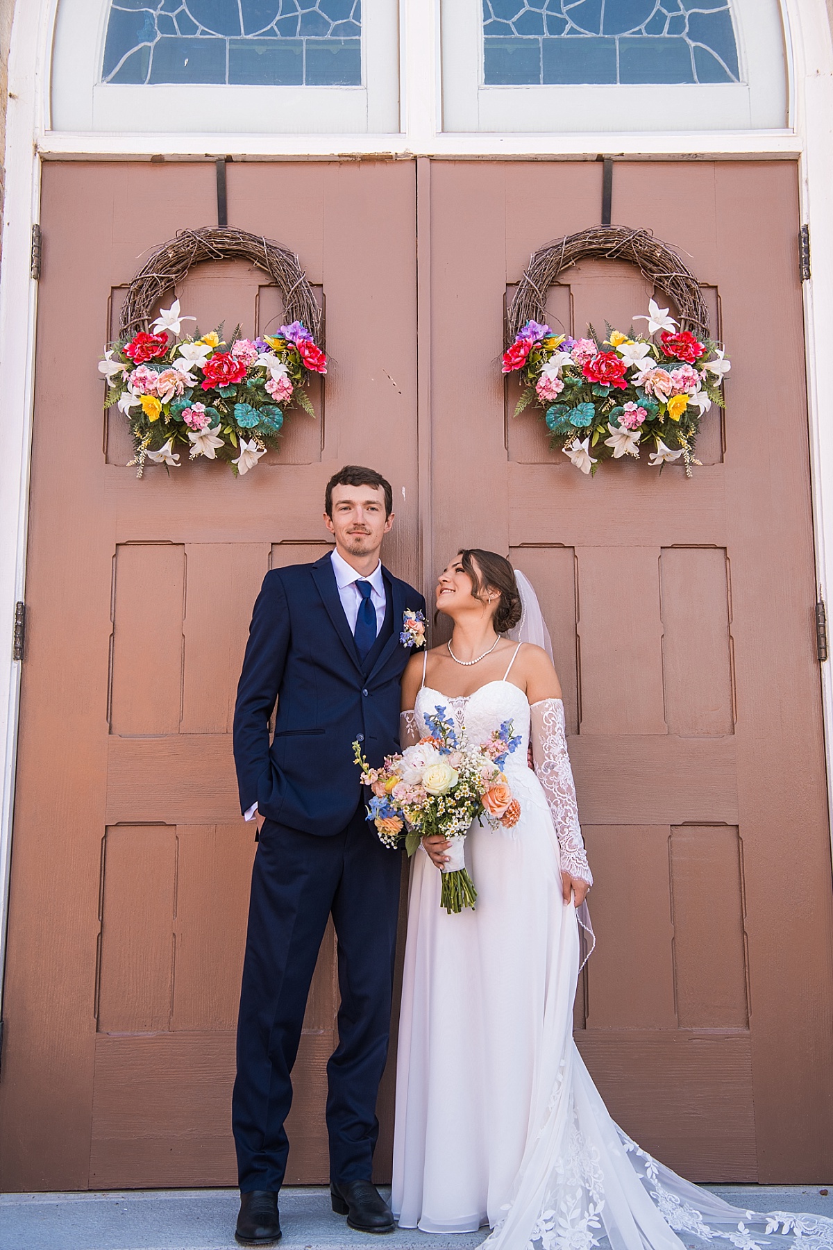 Grace and Alex pose outside Ste. Genevieve Catholic Church after their ceremony