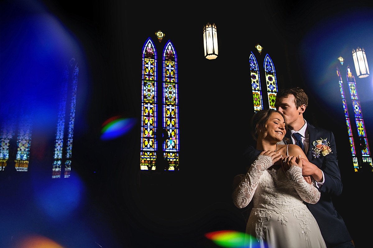 Grace and Alex share a dramatic portrait inside the church with stained glass windows
