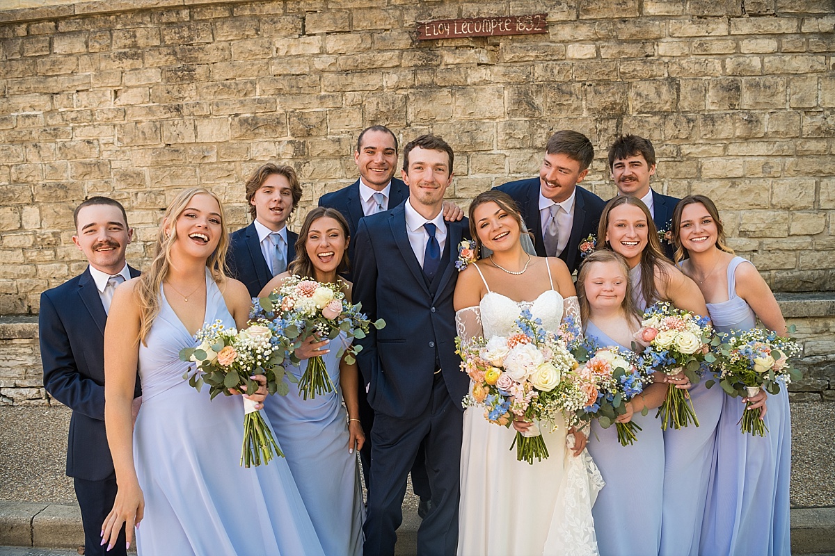 Grace, Alex, and their wedding party laugh together in downtown Ste. Genevieve