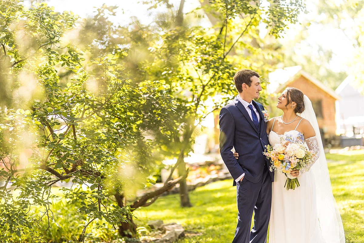 Grace and Alex walk together through a garden during their Ste. Genevieve wedding portraits