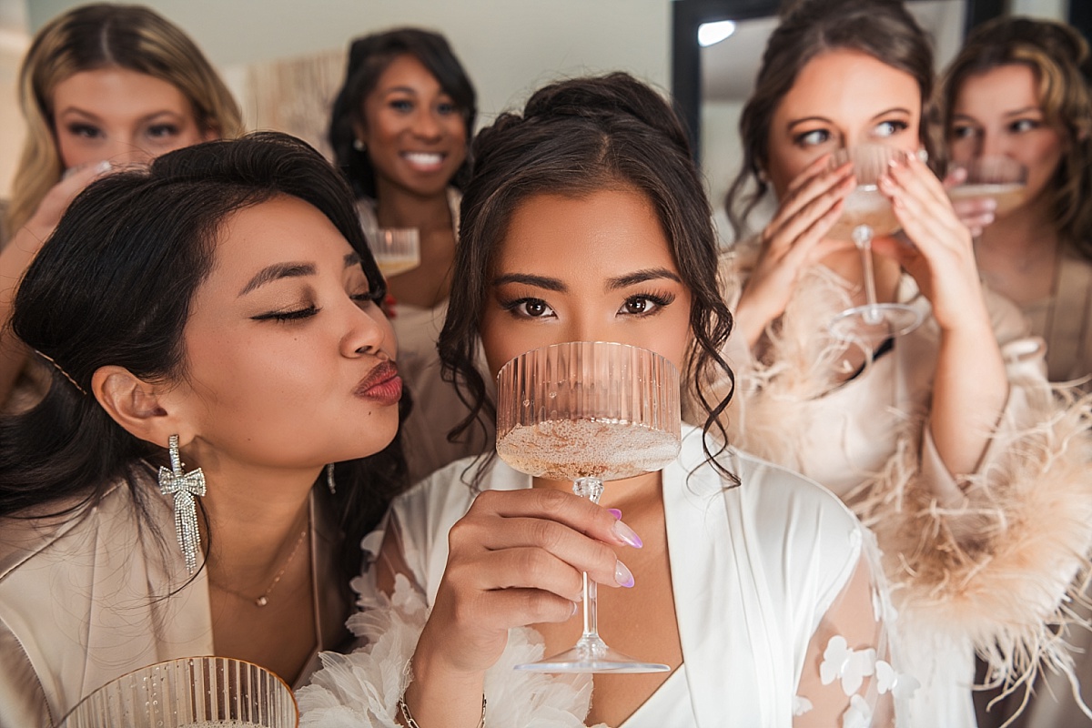 Melicia celebrates with her bridesmaids and friends over champagne during wedding preparations.