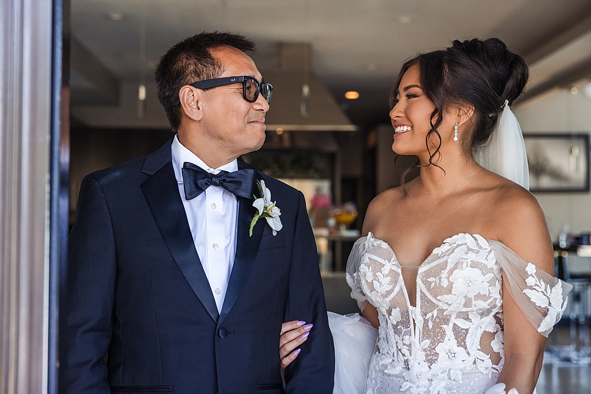 Melicia smiles at her father in his tuxedo as they share a moment before the ceremony.