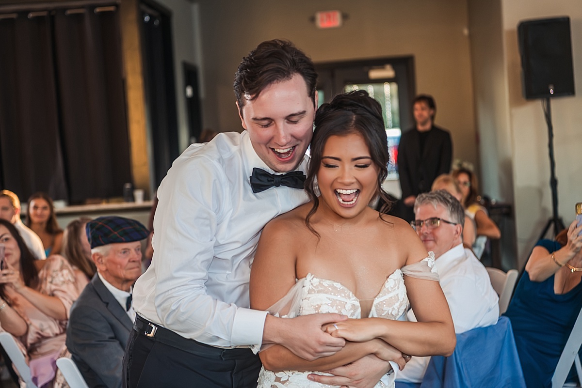 Justin and Melicia laugh together while dancing at their wedding reception.
