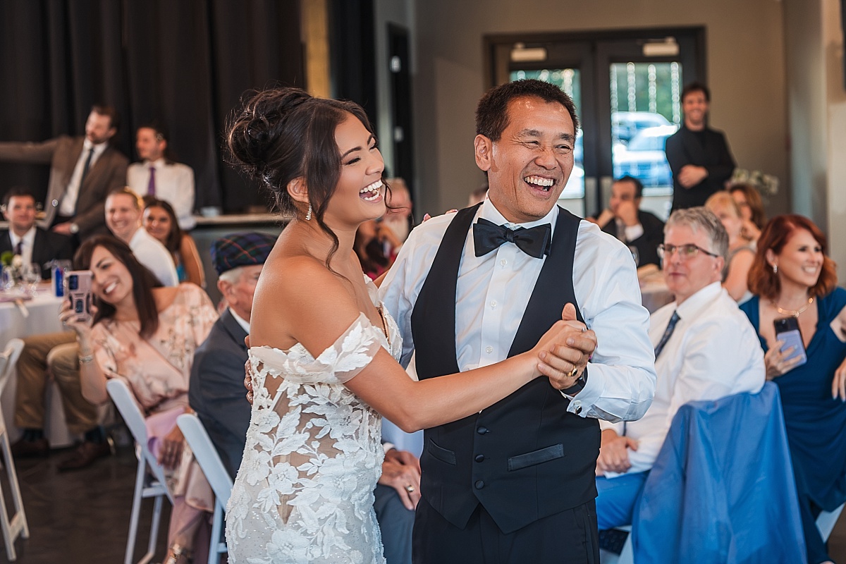Melicia shares a joyful dance with her father as family and friends watch and smile.